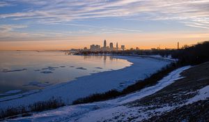 Preview wallpaper coast, lake, winter, snow, city, sunrise