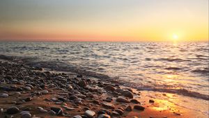 Preview wallpaper coast, pebbles, stones, sea, nature, sunset