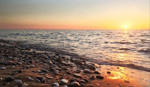 Preview wallpaper coast, pebbles, stones, sea, nature, sunset