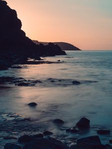 Preview wallpaper coast, rocks, sea, stones, dusk