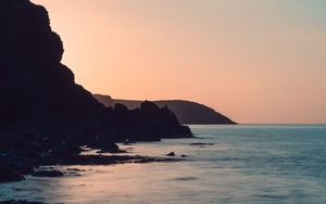 Preview wallpaper coast, rocks, sea, stones, dusk
