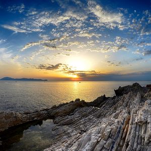 Preview wallpaper coast, rocks, sea, horizon, sun, sunset