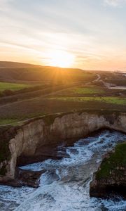 Preview wallpaper coast, rocks, sea, water, sun, landscape, aerial view