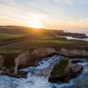 Preview wallpaper coast, rocks, sea, water, sun, landscape, aerial view