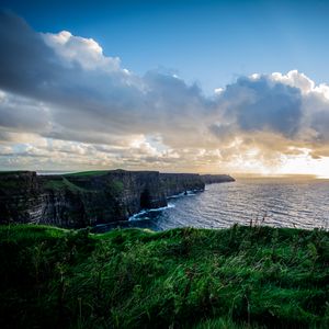 Preview wallpaper coast, rocks, sea, grass, nature