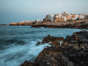 Preview wallpaper coast, rocks, sea, buildings, city