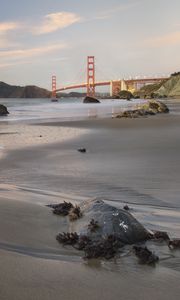 Preview wallpaper coast, sand, stones, sea, bridge