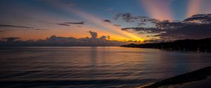 Preview wallpaper coast, sea, clouds, rays, sunset, dark