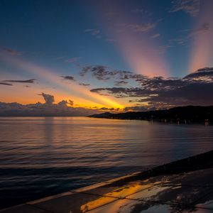 Preview wallpaper coast, sea, clouds, rays, sunset, dark