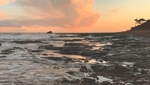 Preview wallpaper coast, sea, pebbles, stones, sunset