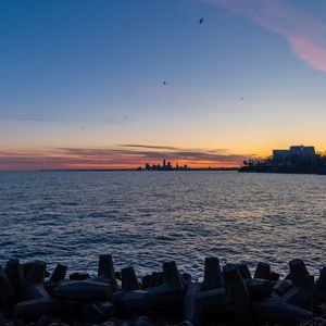 Preview wallpaper coast, sea, water, buildings, horizon, twilight