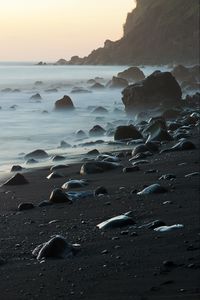 Preview wallpaper coast, stones, rock, sea, landscape, twilight