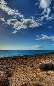 Preview wallpaper coast, stones, sandy, clouds, sky, sun