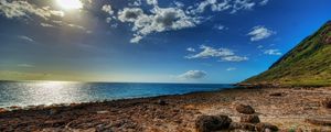 Preview wallpaper coast, stones, sandy, clouds, sky, sun