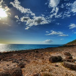 Preview wallpaper coast, stones, sandy, clouds, sky, sun