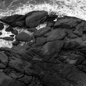 Preview wallpaper coast, stones, sea, waves, black and white, aerial view