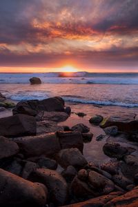 Preview wallpaper coast, stones, sea, sun, sunset