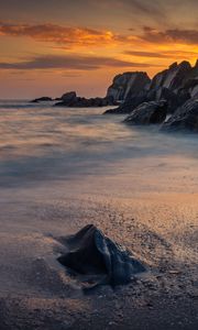 Preview wallpaper coast, sunset, rocks, sea, sand