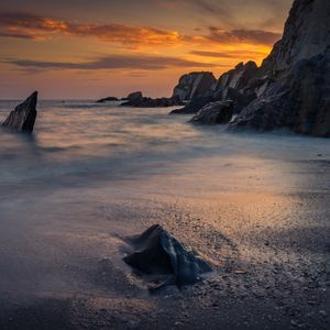 Preview wallpaper coast, sunset, rocks, sea, sand