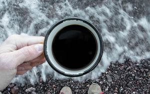 Preview wallpaper coffee, cup, legs, hand, pebbles, sea