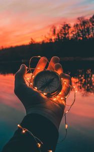 Preview wallpaper compass, garland, hand, river, evening