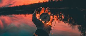 Preview wallpaper compass, garland, hand, river, evening