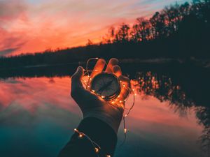 Preview wallpaper compass, garland, hand, river, evening