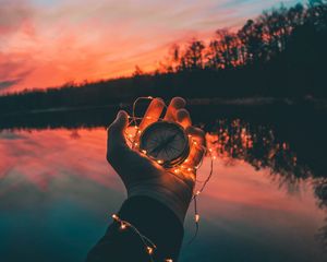 Preview wallpaper compass, garland, hand, river, evening