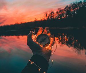 Preview wallpaper compass, garland, hand, river, evening