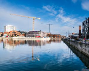 Preview wallpaper construction crane, buildings, river, reflection, ripples