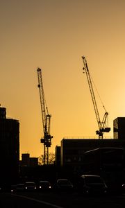 Preview wallpaper construction cranes, buildings, cars, silhouettes, evening