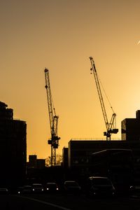 Preview wallpaper construction cranes, buildings, cars, silhouettes, evening