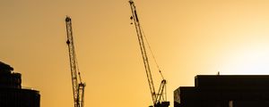 Preview wallpaper construction cranes, buildings, cars, silhouettes, evening