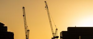 Preview wallpaper construction cranes, buildings, cars, silhouettes, evening