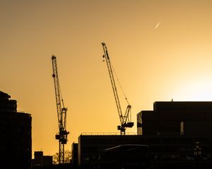 Preview wallpaper construction cranes, buildings, cars, silhouettes, evening