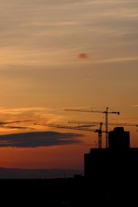 Preview wallpaper construction cranes, buildings, silhouettes, sunset, dark