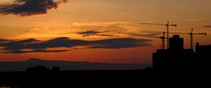 Preview wallpaper construction cranes, buildings, silhouettes, sunset, dark