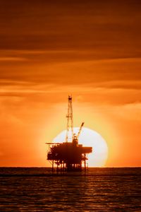 Preview wallpaper construction, sunset, sun, horizon, sea