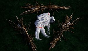 Preview wallpaper cosmonaut, space suit, branches, grass