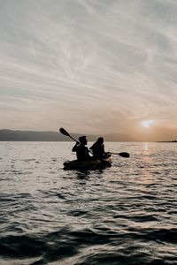 Preview wallpaper couple, boat, silhouettes, water, waves, sunset, dark