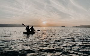 Preview wallpaper couple, boat, silhouettes, water, waves, sunset, dark