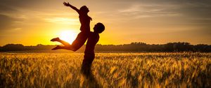 Preview wallpaper couple, love, sunset, field, grass, silhouettes