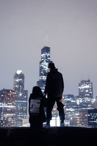 Preview wallpaper couple, roof, love, night city, skyscrapers, overview
