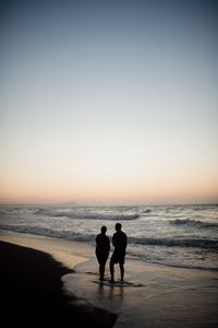 Preview wallpaper couple, silhouettes, coast, sea, twilight, dark