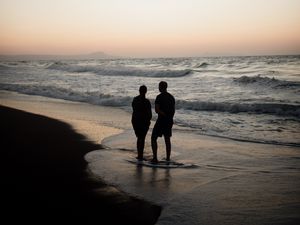 Preview wallpaper couple, silhouettes, coast, sea, twilight, dark