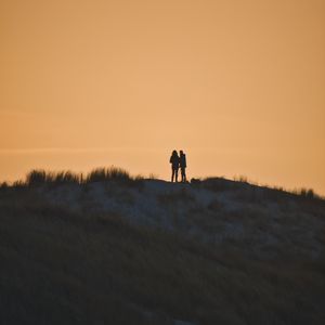 Preview wallpaper couple, silhouettes, hill, grass, evening