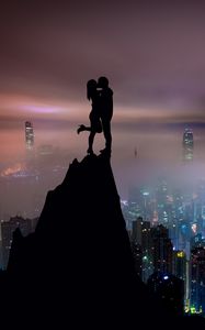 Preview wallpaper couple, silhouettes, kiss, hill, city, skyscrapers