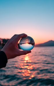 Preview wallpaper crystal ball, ball, hand, sunset, reflection