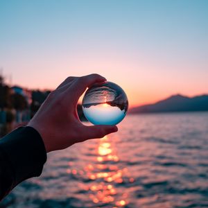 Preview wallpaper crystal ball, ball, hand, sunset, reflection