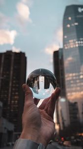 Preview wallpaper crystal ball, ball, hand, reflection, city, buildings